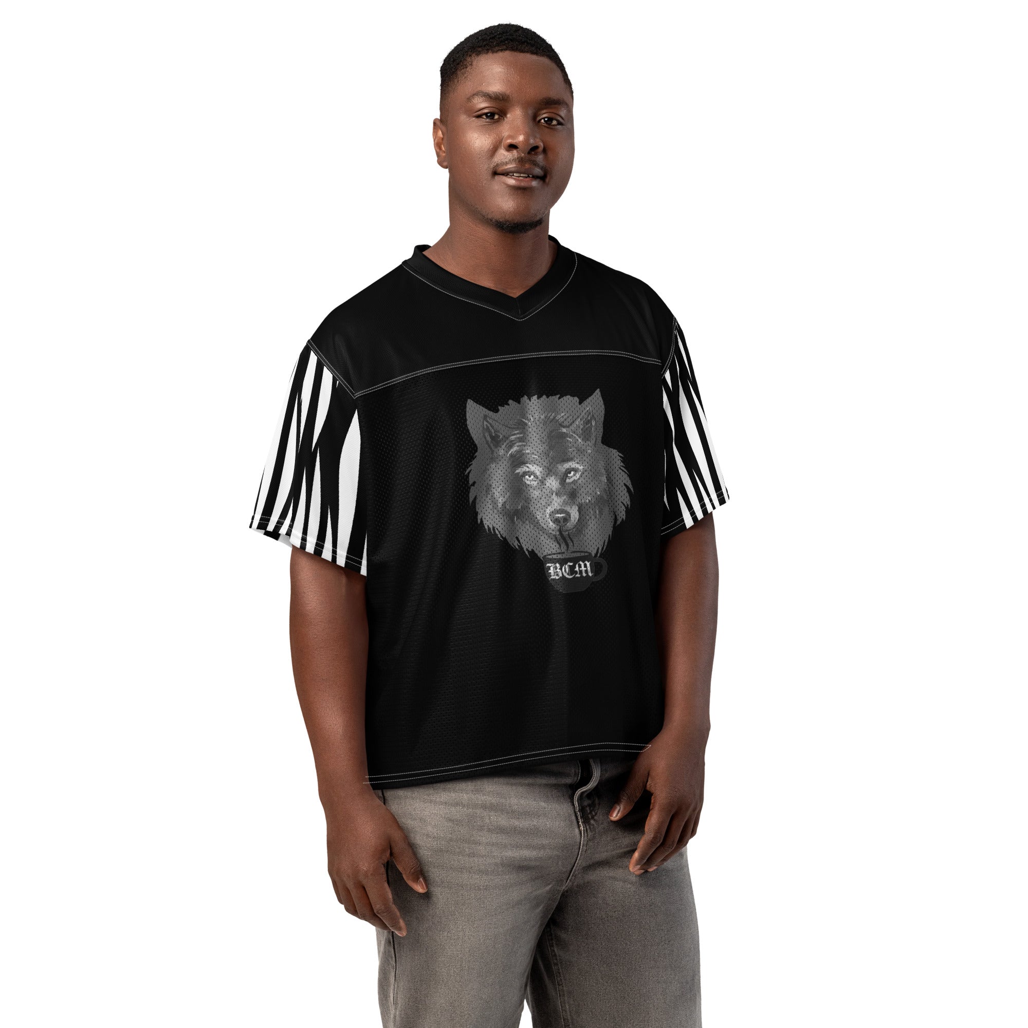 At The Monster Café Brew Crew Jersey — front view on model, black boxy football jersey with wolf head and BCM mug graphic centered on chest, zebra stripe sleeves