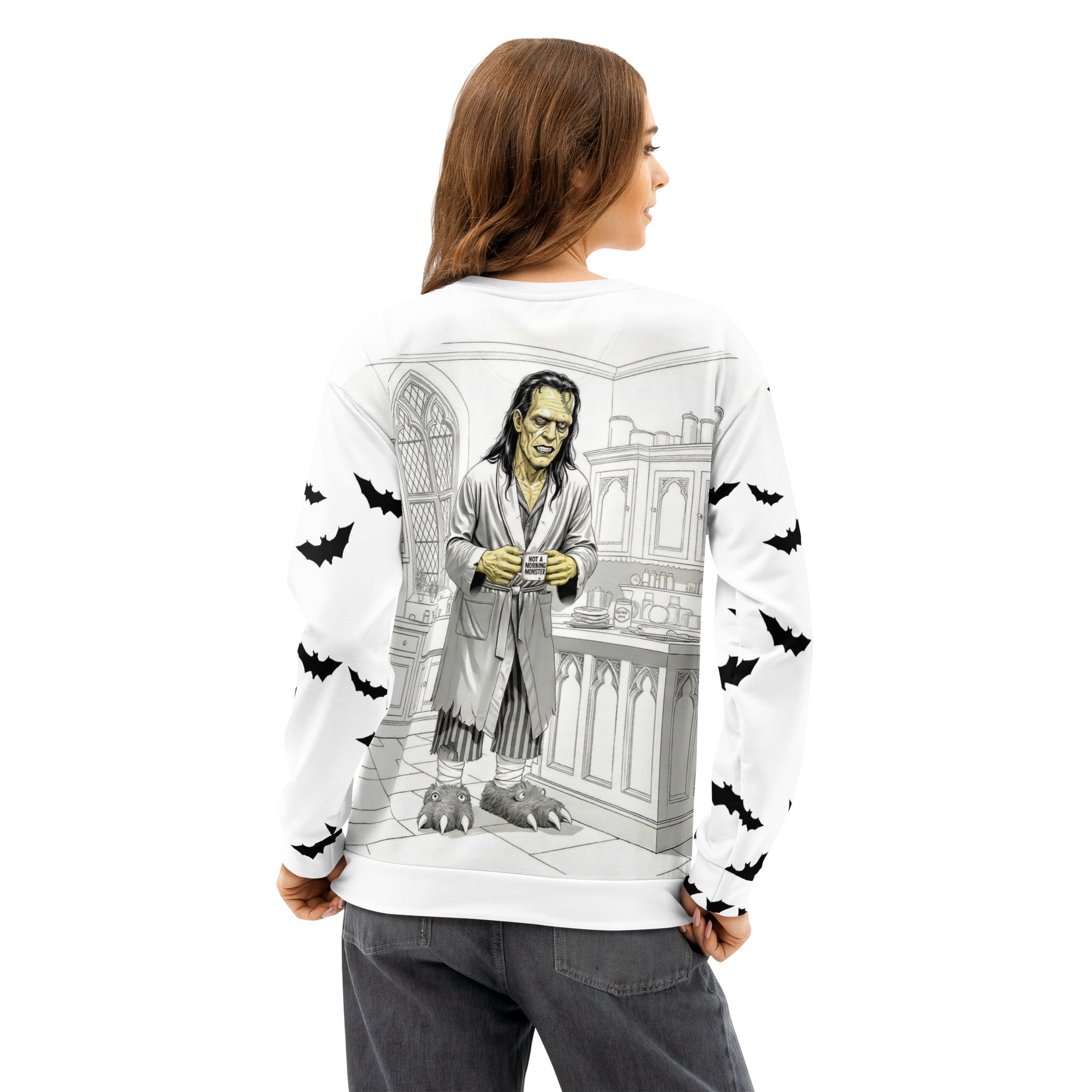 All over print unisex cotton sweatshirt - Brew-kenstein holding coffee mug with "not a morning monster" print - kitchen view - monster wearing bathrobe and monster slippers - bats on sleeves -2XS-6XL - back view 