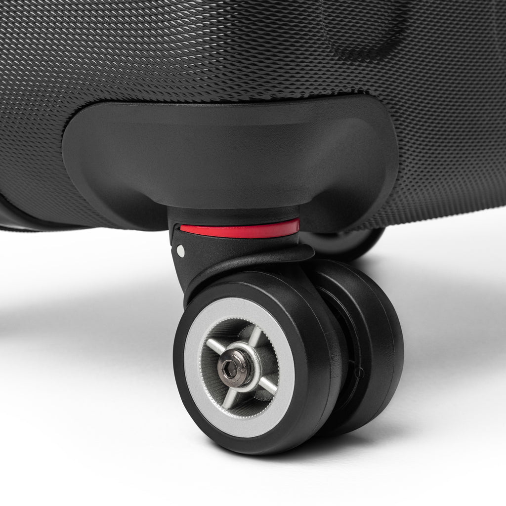 Close-up of Monster Brew suitcase 360-degree swivel wheel with red accent detail