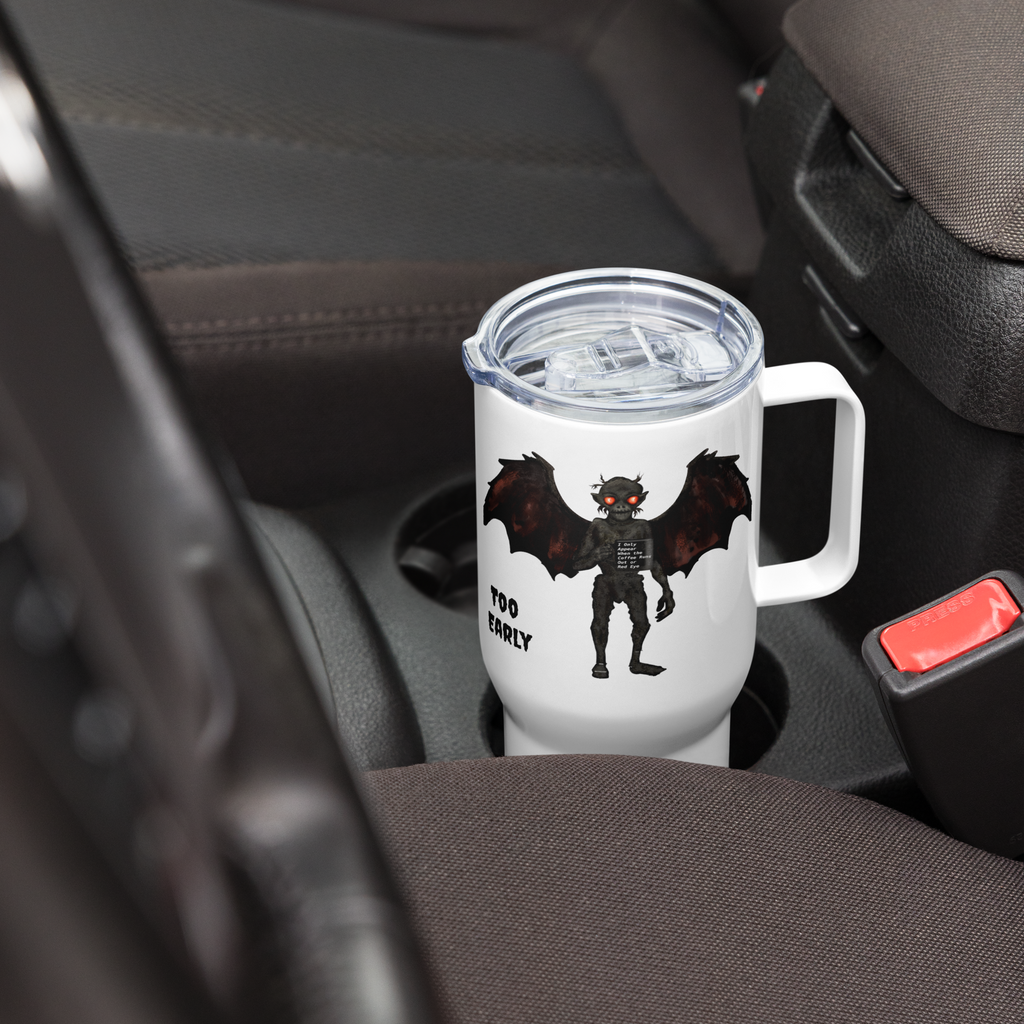 White tumbler with a mothman design and text in a car cup holder -25 oz