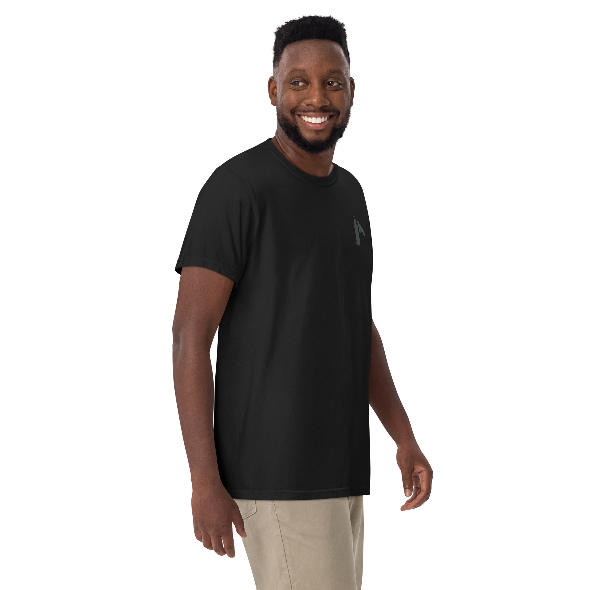 Man wearing a black t-shirt with a small graphic of claw and coffee thermos on left shoulder