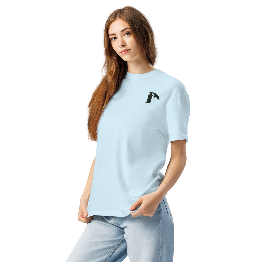 Woman wearing a light blue t-shirt with a small graphic of claw and coffee thermos