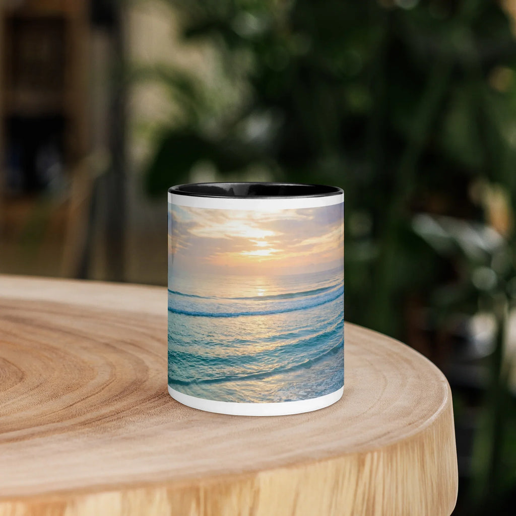 White ceramic mug with black interior featuring a calming ocean sunset design on a wooden table
