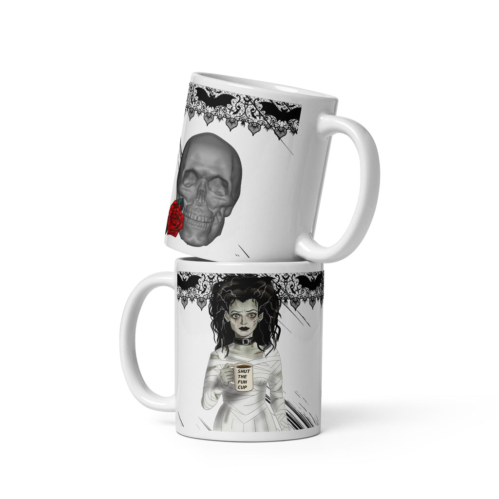 Shut the Fuh Cup Mug - Bride of Frankenstein Coffee Gothic | Brew Crew- Premium white ceramic mug -right view- skull with red rose and gothic bat lace on top rim
Left view- Frankenstein's monsters bride wearing a white dress made of bandages, and a black choker - her hair is disheveled  and with her blank stare she holds her coffee mug with text "shut the fuh cup" written. Gothic bat lace on top rim - 11 oz mug view
