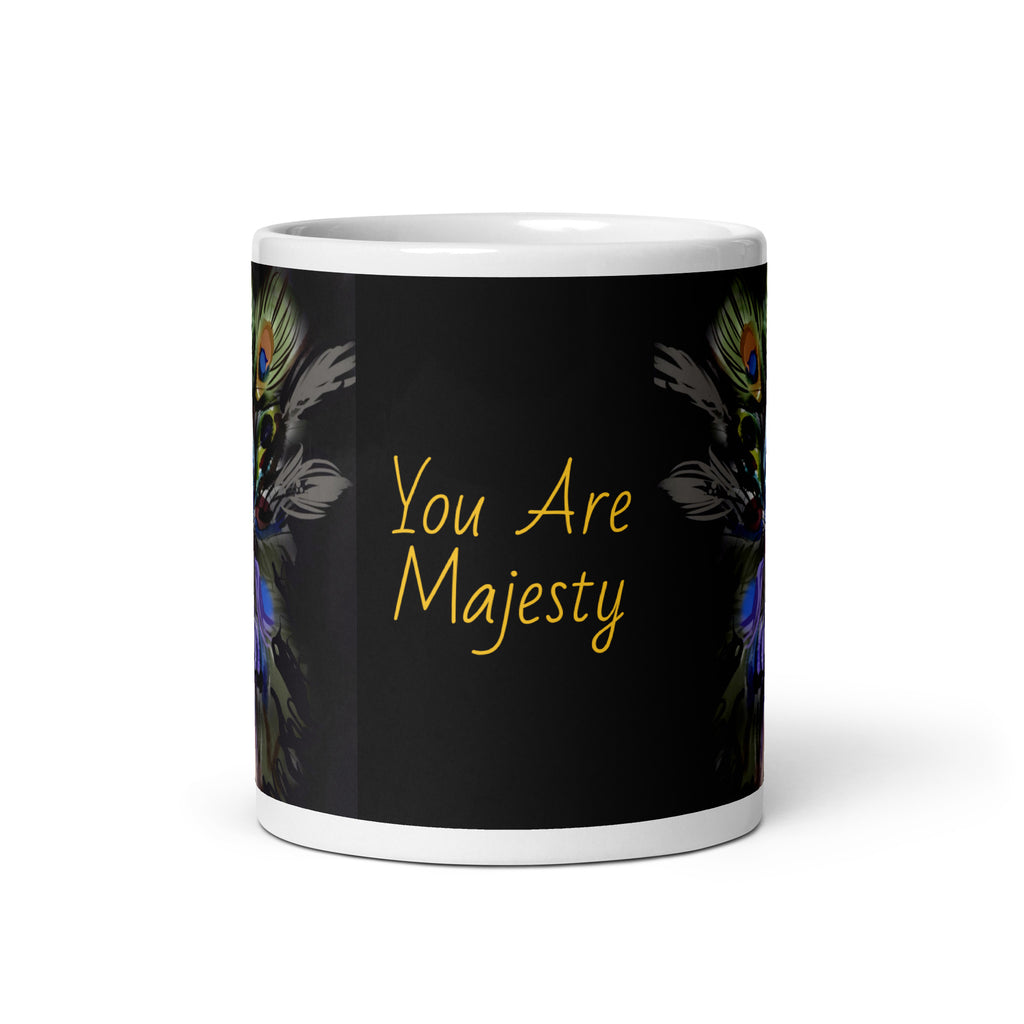 Stunning Premium white ceramic mug features a majestic woman adorned with vibrant peacock feathers, ornate blue and orange face paint, and a regal purple and green costume. With the inspiring message "You Are Majesty, 11- oz front view
