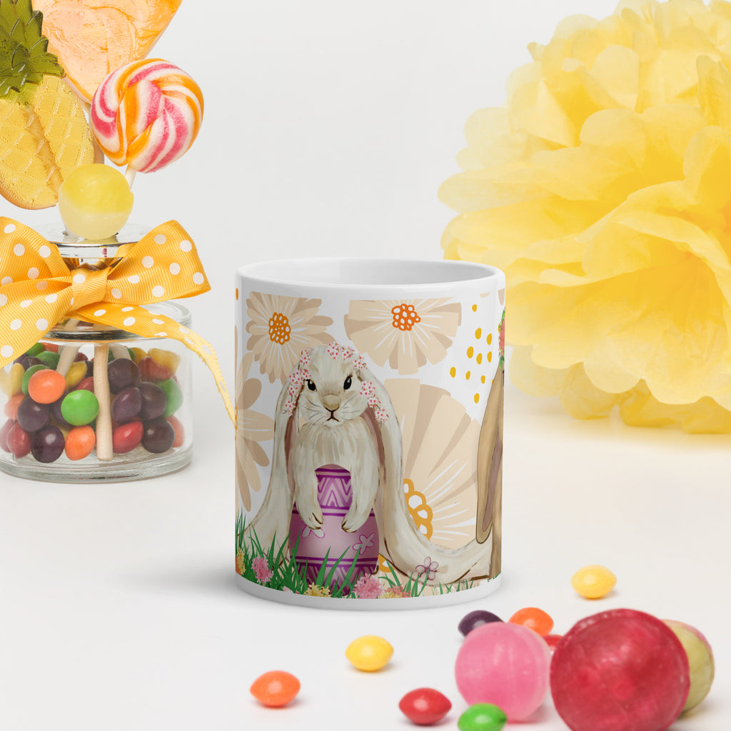 Premium white ceramic mug- Easter Bunny Trio -Features  adorable floppy eared bunny holding  a pink easter egg in a floral garden with abstract yellow floral background - 11 oz front view