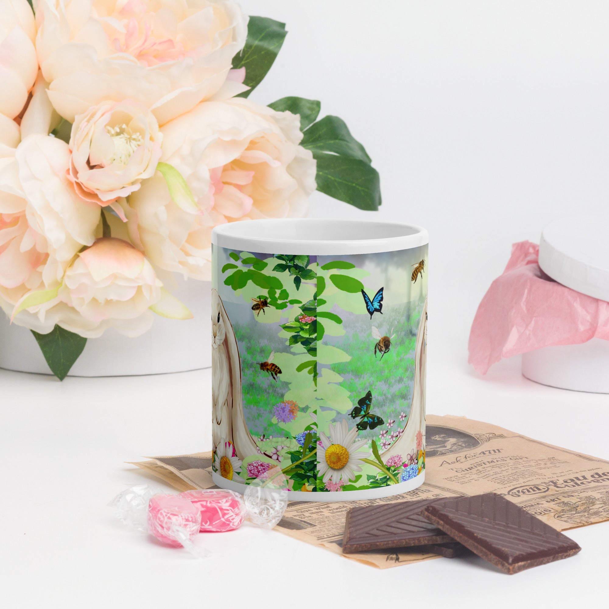 Premium white ceramic- Floppy Eared Easter Bunny Mug- Forest setting adorable floppy eared bunny surrounded by flowers ,butterflies and a few bees. 11 oz - front view