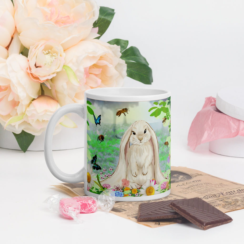 Premium white ceramic- Floppy Eared Easter Bunny Mug- Forest setting adorable floppy eared bunny surrounded by flowers ,butterflies and a few bees. 11 oz - front view