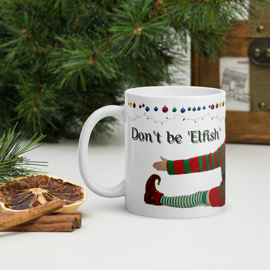 Premium white ceramic - Don't be Elfish - Pour me a cup! - Coffee mug - features cheeky elf dressed in holiday colors hugging the mug with colorful ornaments border at the top- 11 oz left view