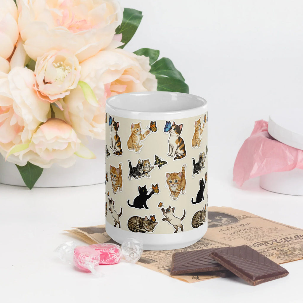 Ceramic mug with playful cat and butterfly design, styled on table with flowers and candy