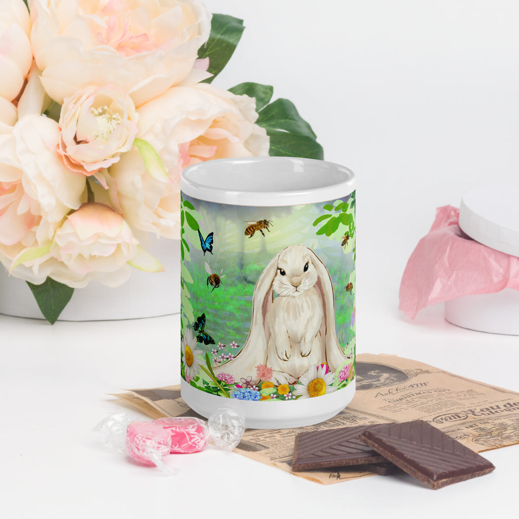 Premium white ceramic- Floppy Eared Easter Bunny Mug- Forest setting adorable floppy eared bunny surrounded by flowers ,butterflies and a few bees. 15 oz - front view