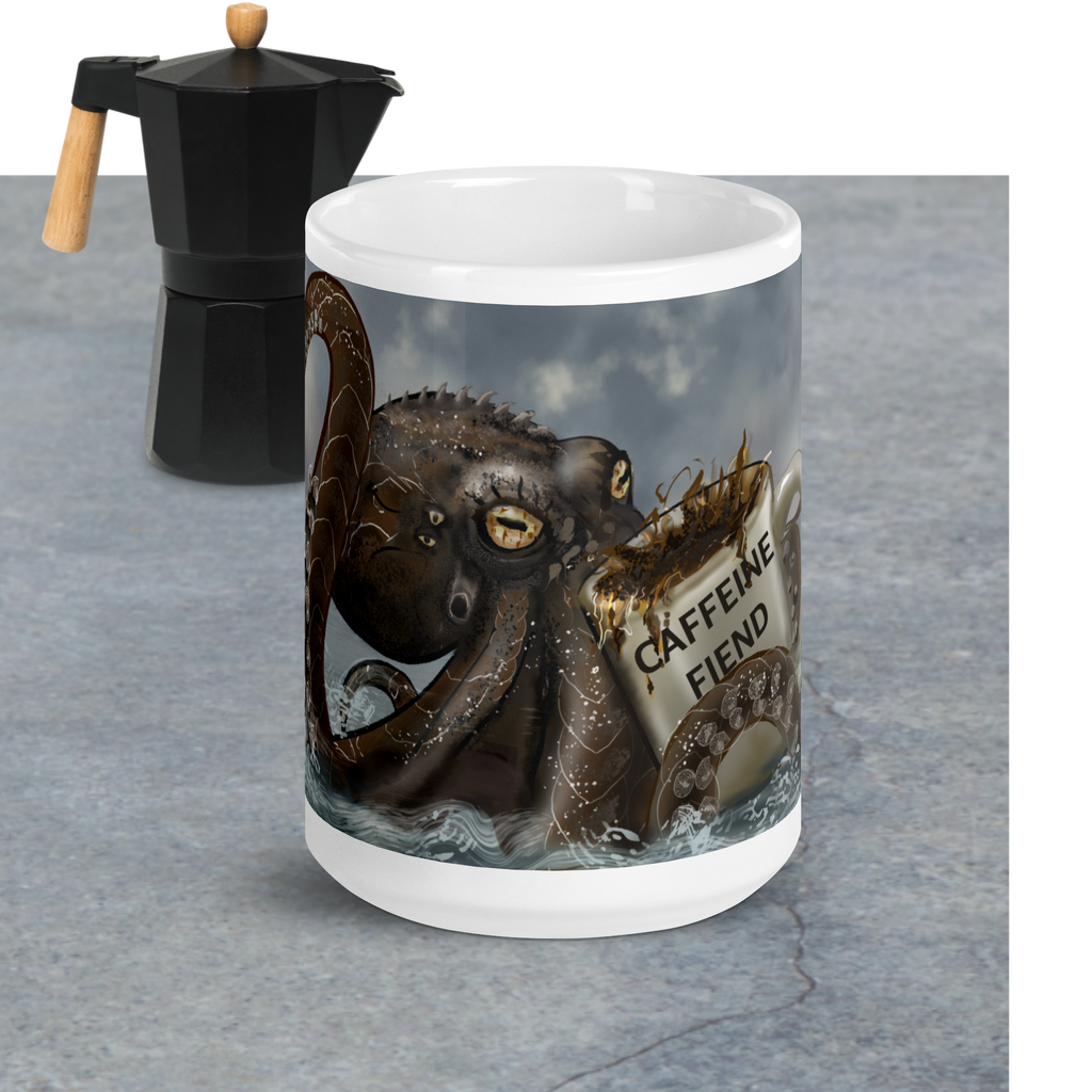 Premium ceramic with Kraken design and 'Caffeine Fiend' text next to a Moka pot on a gray surface - 15 oz front view