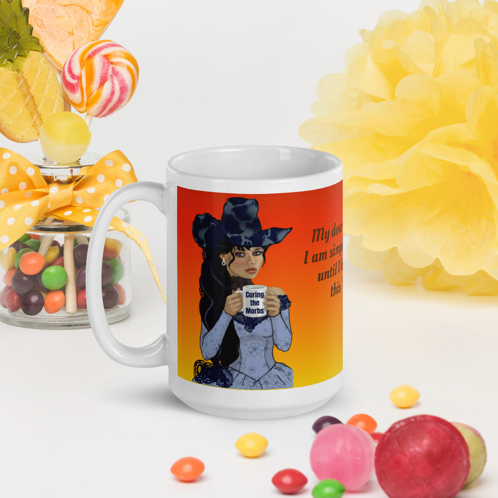 Stunning Premium white ceramic mug features a gorgeous gothic Victorian lady with incredible dark blue floral hat and long flowing hair, pale porcelain skin, and striking features. Dressed in an elegant blue corset-style dress, she holds a mug that says "Curing the Morbs."  15 - oz left view