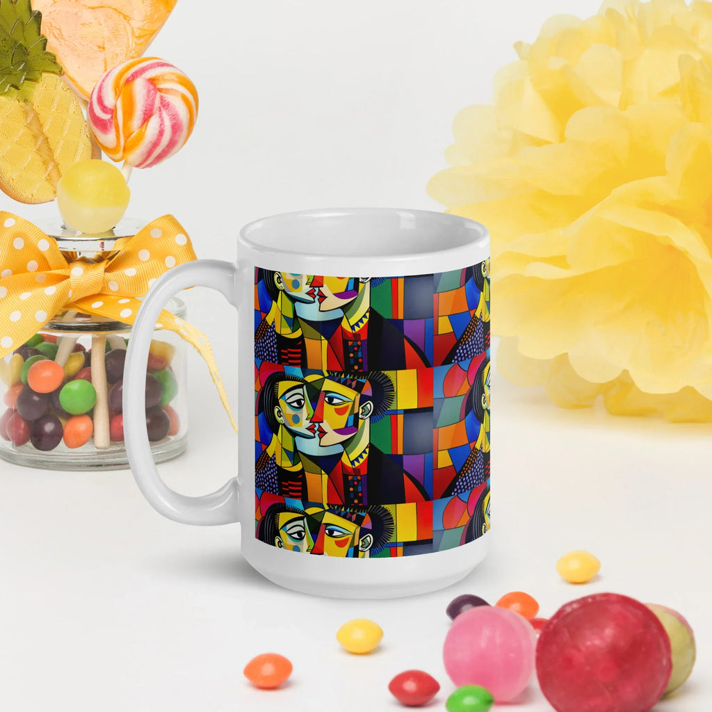 White glossy ceramic mug with colorful geometric abstract face design, surrounded by candies