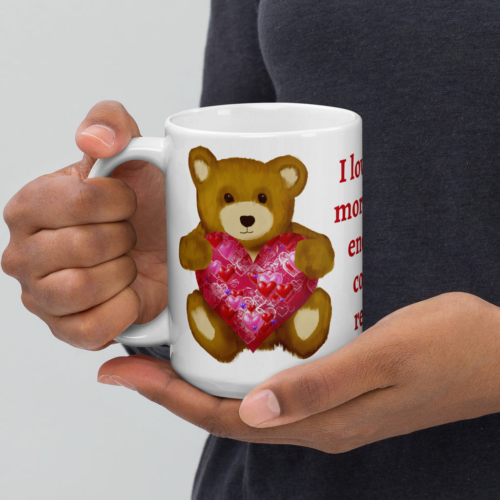 Premium White Ceramic mug - held in persons hand on a table with party decorations and colored candy - Valentines Day Bear with geometric Pink and red heart coffee mug. 15 oz - left view