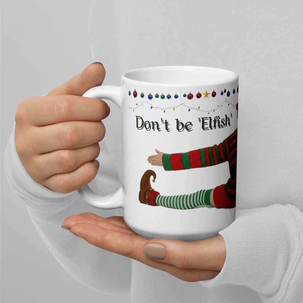 Premium white ceramic - Don't be Elfish - Pour me a cup! - Coffee mug - features cheeky elf dressed in holiday colors hugging the mug with colorful ornaments border at the top- 15 oz left view