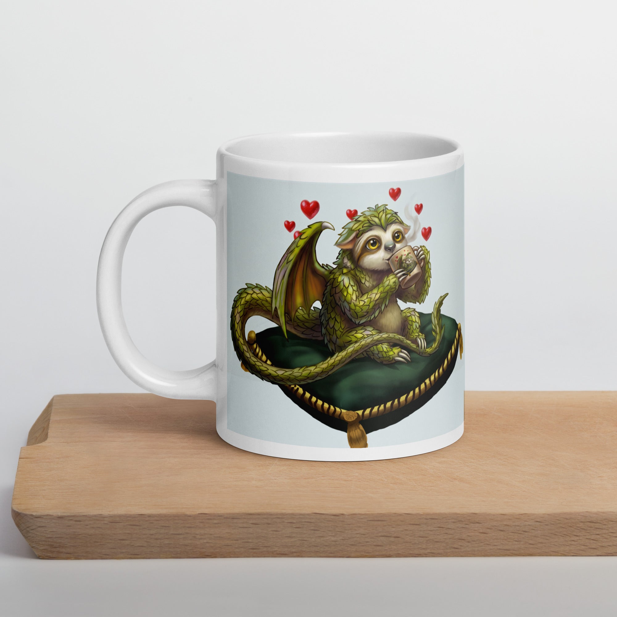 Sleepy Sloth Dragon mug on wooden cutting board — awake dragon holding coffee cup with hearts, gothic fantasy ceramic mug - 20 oz left view