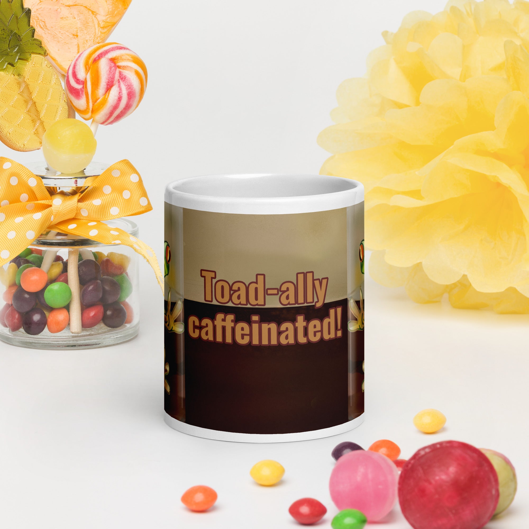 Premium white ceramic - Toad-ally caffeinated - text on coffee mug- features a bright green and blue tree frog peeking through the coffee with bright orange eyes - 20 oz front view