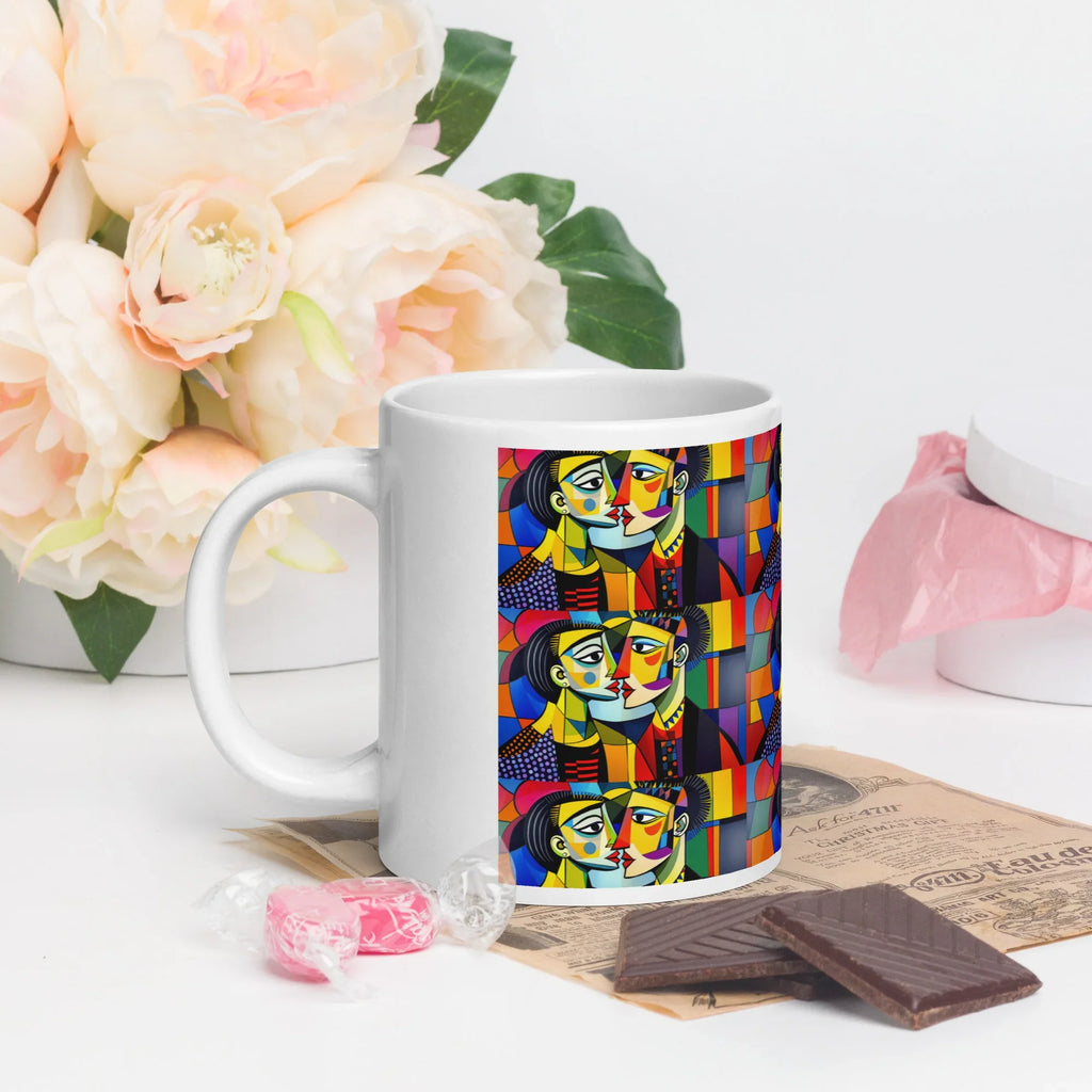 White ceramic mug with colorful abstract art design, flowers and chocolates beside it