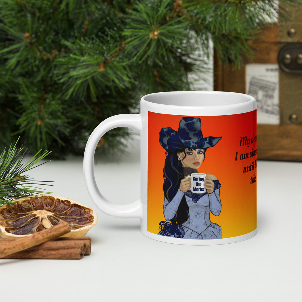 Stunning Premium white ceramic mug features a gorgeous gothic Victorian lady with incredible dark blue floral hat and long flowing hair, pale porcelain skin, and striking features. Dressed in an elegant blue corset-style dress, she holds a mug that says "Curing the Morbs."  20 - oz left view