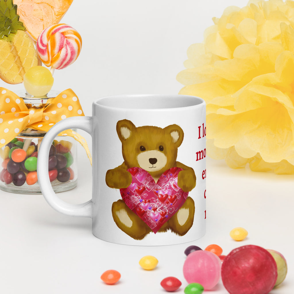 Premium White Ceramic mug - held in persons hand on a table with party decorations and colored candy - Valentines Day Bear with geometric Pink and red heart coffee mug. 20 oz - left view