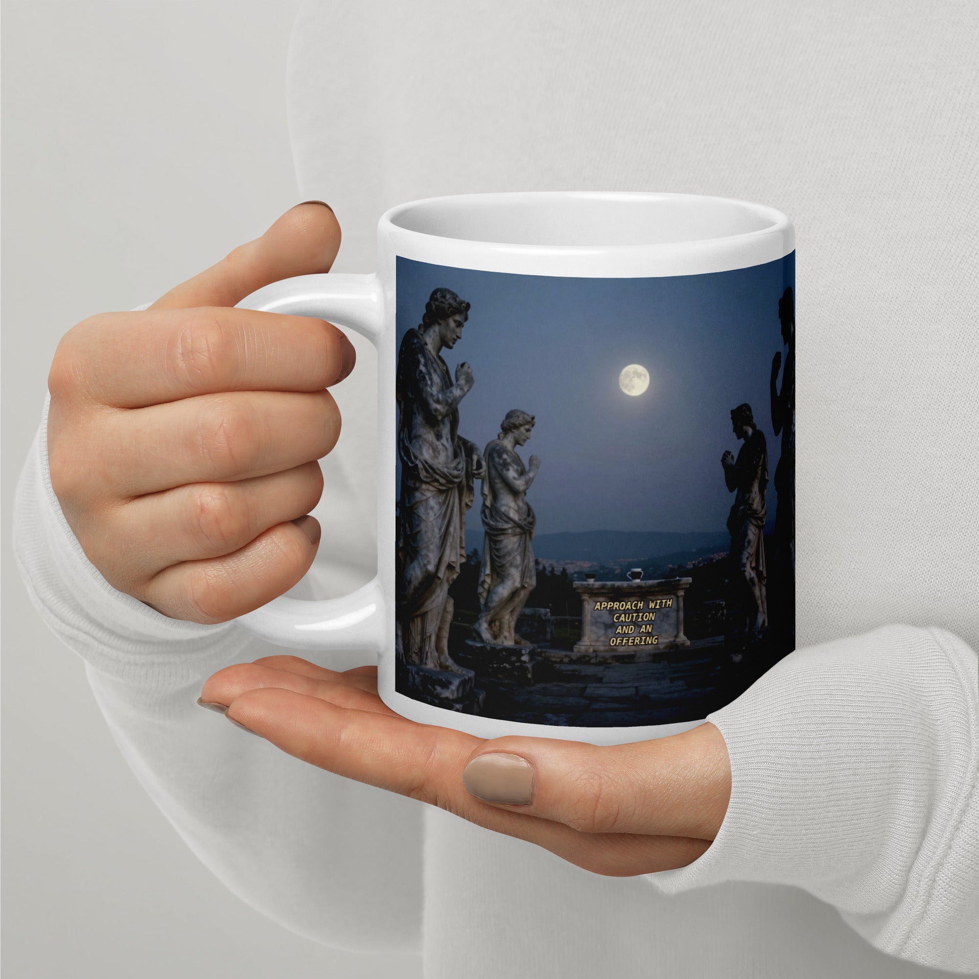Medusa mug left view showing stone statues under a full moon with the inscription "Approach with Caution and an Offering" — 20 oz glossy white ceramic mug by Brew Crew Mugs
