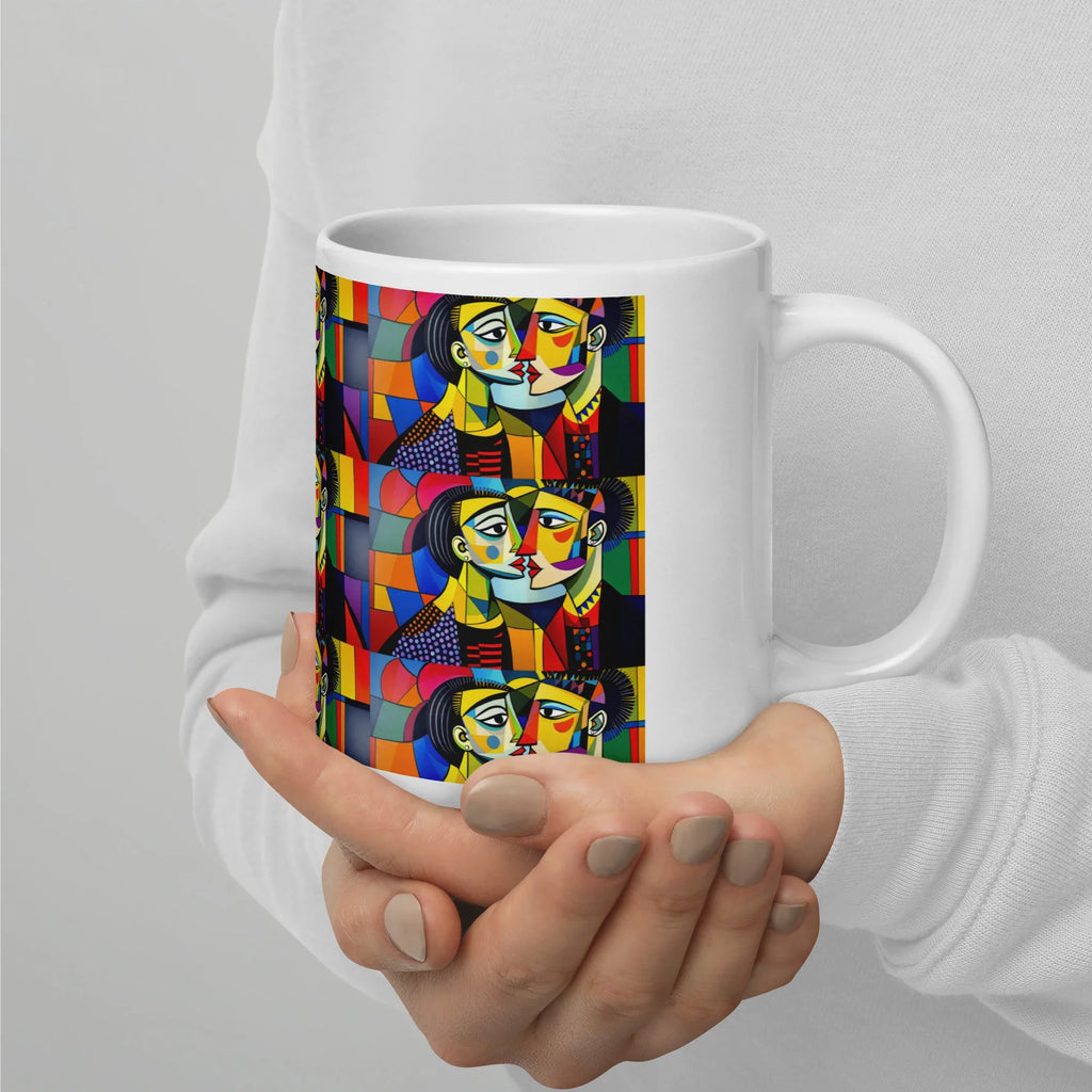 White ceramic mug with colorful abstract faces art, held in two hands, 20 oz size