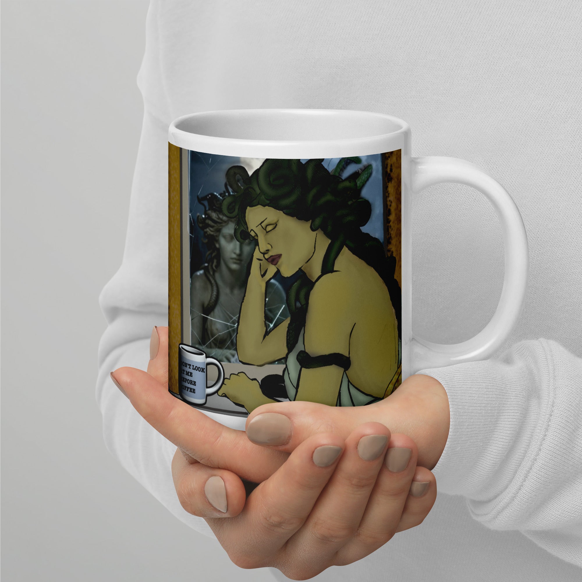 (Medusa at vanity): Medusa mug right view showing Medusa slumped at a cracked mirror vanity, snakes in her hair, a mini mug that reads "Don't Look at Me Before Coffee" — 20 oz glossy white ceramic mug by Brew Crew Mugs