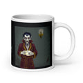Dracula Coffee Mug - I Have Crossed Oceans of Time to Find a Barista- Premium white ceramic mug with Dracula standing in his castle wearing burgundy bathrobe with gold trim - a candelabra on the wall- he is holding a coffee mug with text " I never drink......decaf" - 20 oz right view- held in persons hand